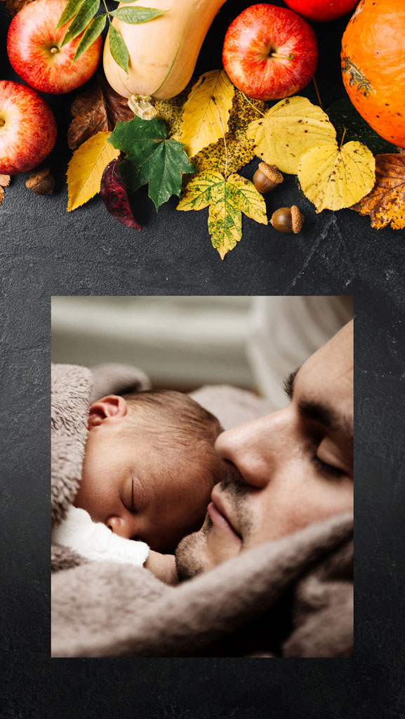 A man kissing a sleeping baby on the forehead