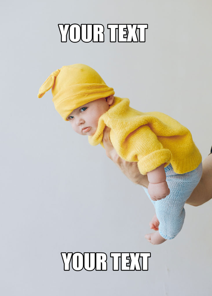 Baby in yellow clothing being supported by a person's hand