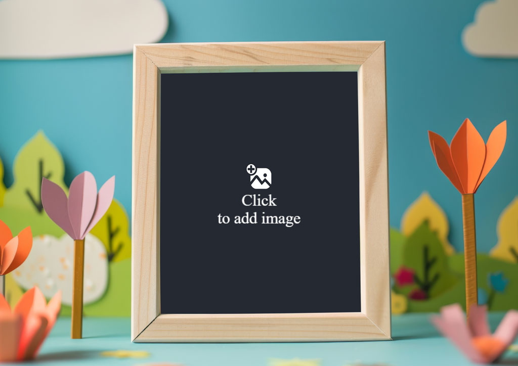 A blank wooden chalkboard with a light frame, surrounded by paper flowers and leaves on a blue surface.