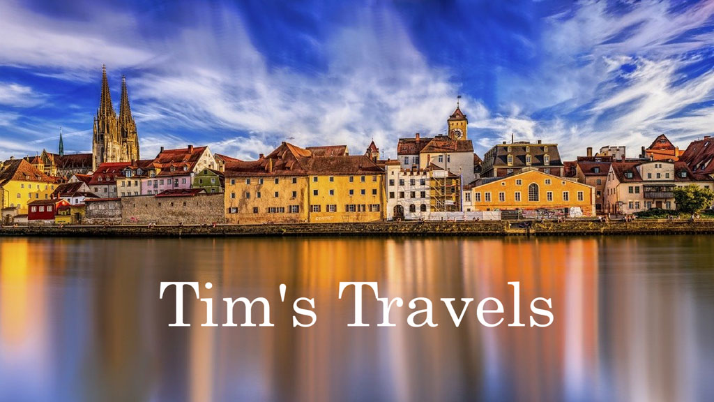 A picturesque European town by a river with historic buildings and a church steeple