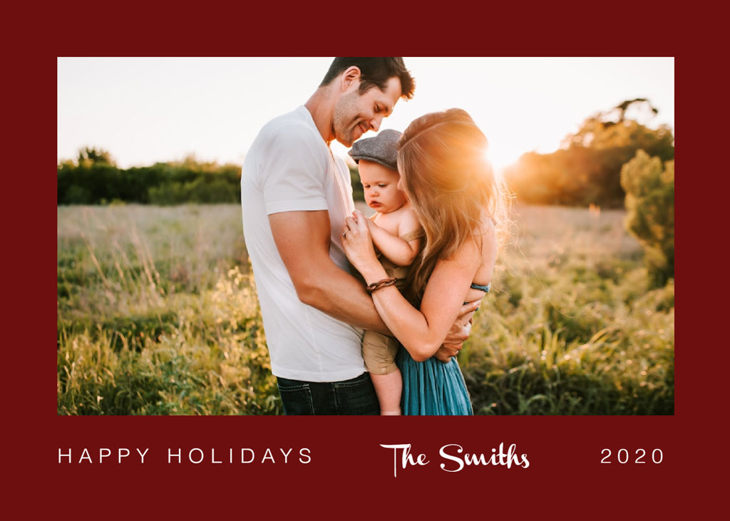 Family of three embracing in a field