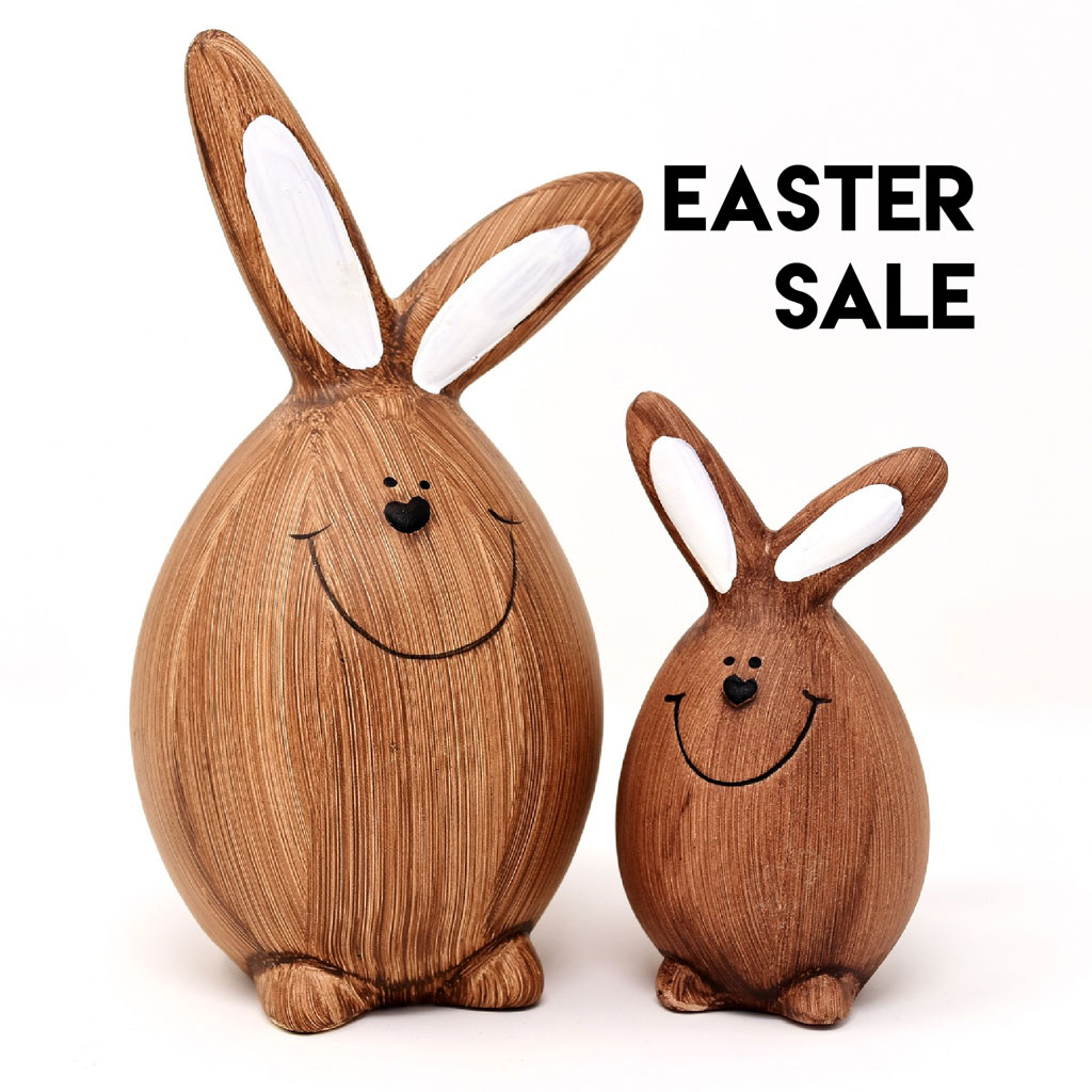 Two wooden Easter bunnies with smiling faces and white inner ears