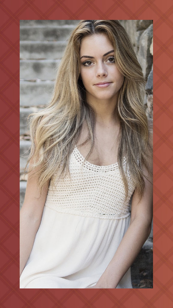 A woman with long blonde hair wearing a white crocheted top dress, sitting on stone steps.