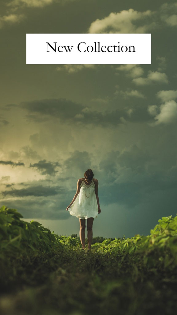 Woman in a white dress standing in a field with a cloudy sky