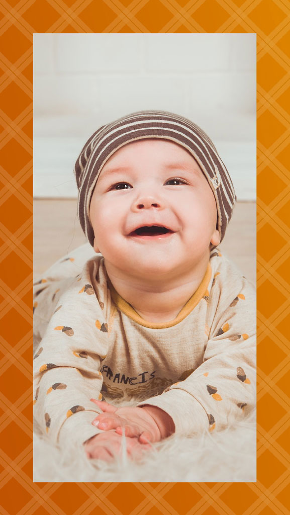 Baby in a striped hat and fall-themed onesie
