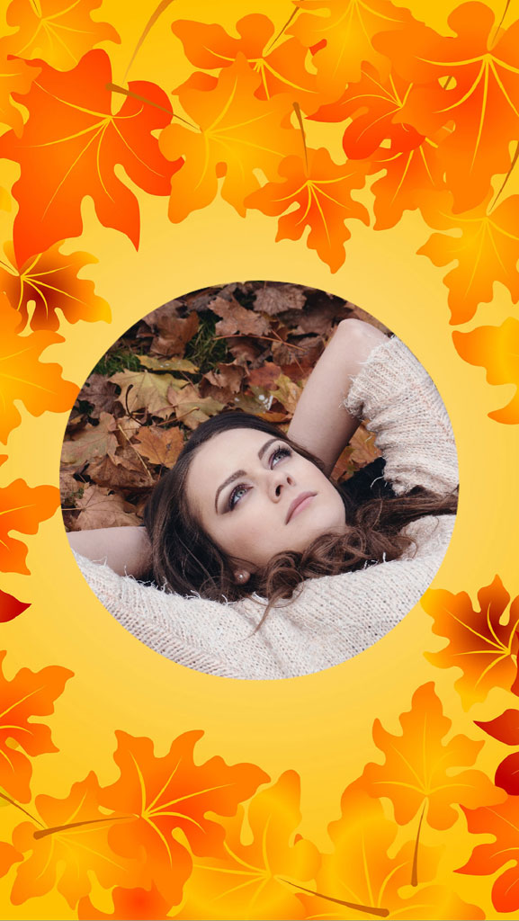 Young woman lying on autumn leaves with a peaceful expression