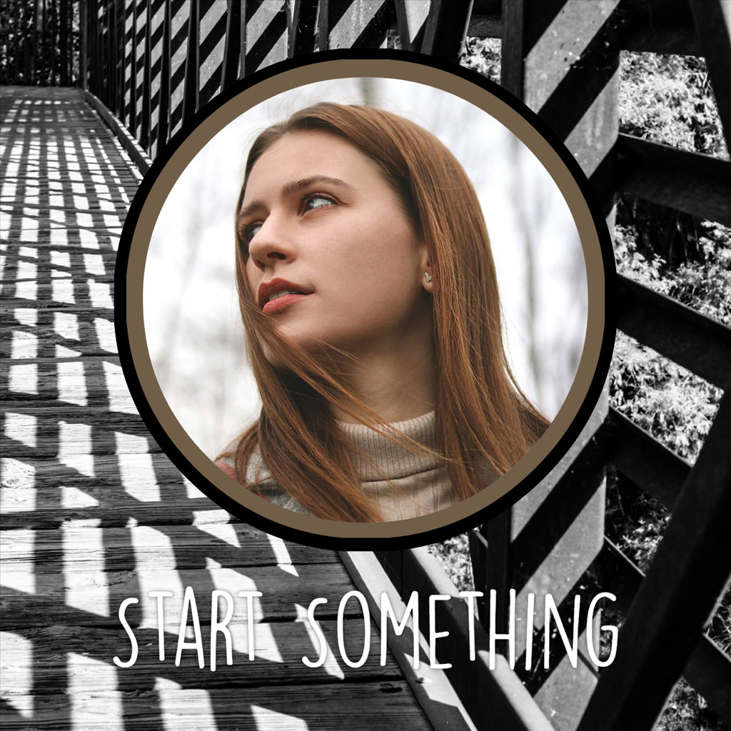 Young woman with long red hair on a wooden bridge