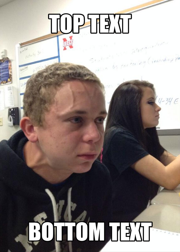 A man and woman sitting at a desk in a classroom with a whiteboard behind them.