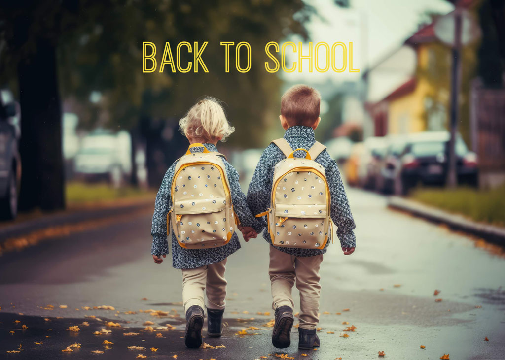 Two boys with backpacks walking down a street