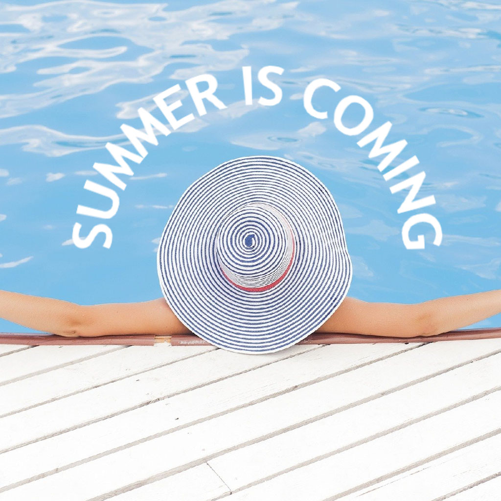Person relaxing by the pool with a striped sun hat