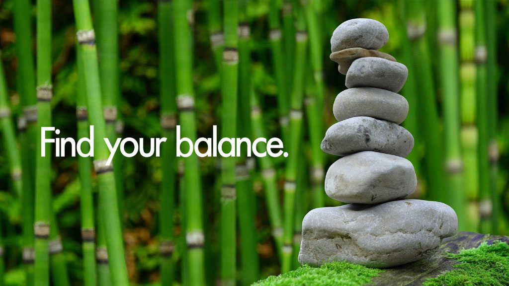 Stacked stones in front of bamboo forest with 'Find your balance' text