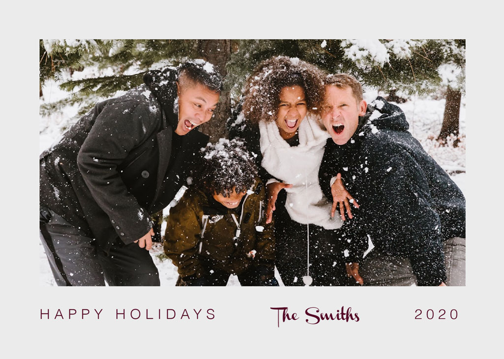 Family of four laughing and playing in the snow