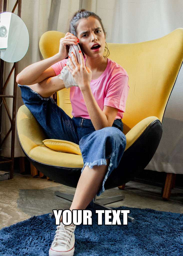 Woman in pink shirt and jeans sitting in a yellow chair on a phone call