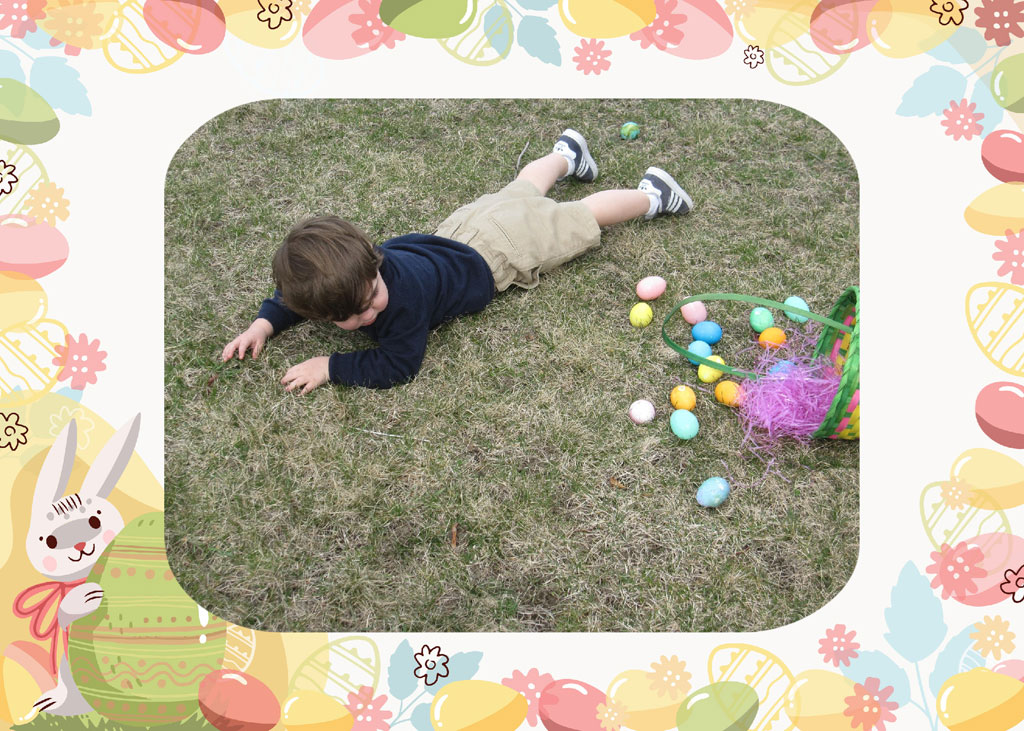 Boy lying on grass with Easter eggs and basket
