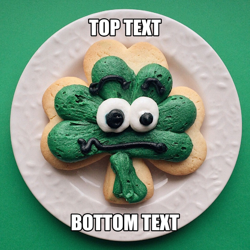 A shamrock-shaped cookie with a face on a white plate