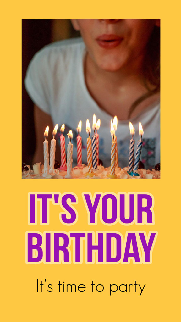 A woman blowing out candles on a birthday cake