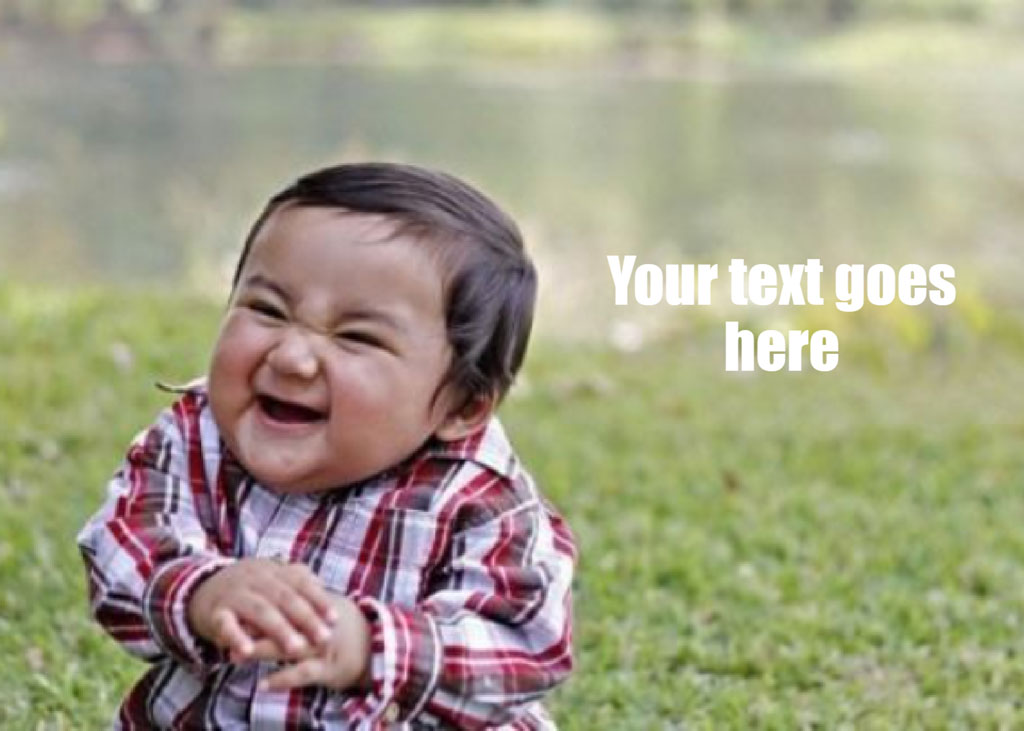 A baby in a red and white plaid shirt laughing on grass