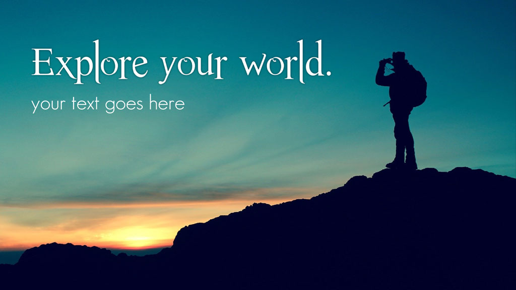 Person standing on a hill, looking through binoculars at sunset