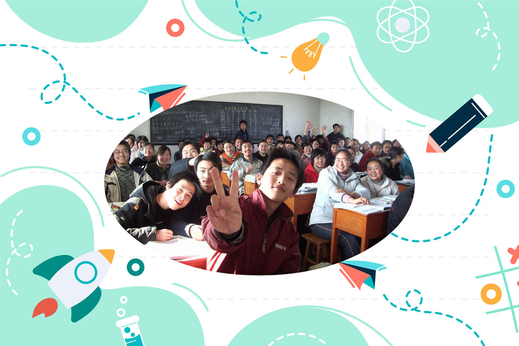 Students in a classroom with a teacher and various educational graphics around them