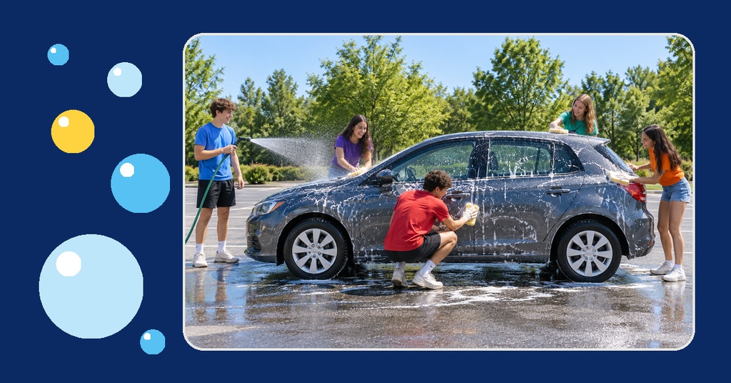 Youth group members washing a car with soap and water in a sunny parking lot.