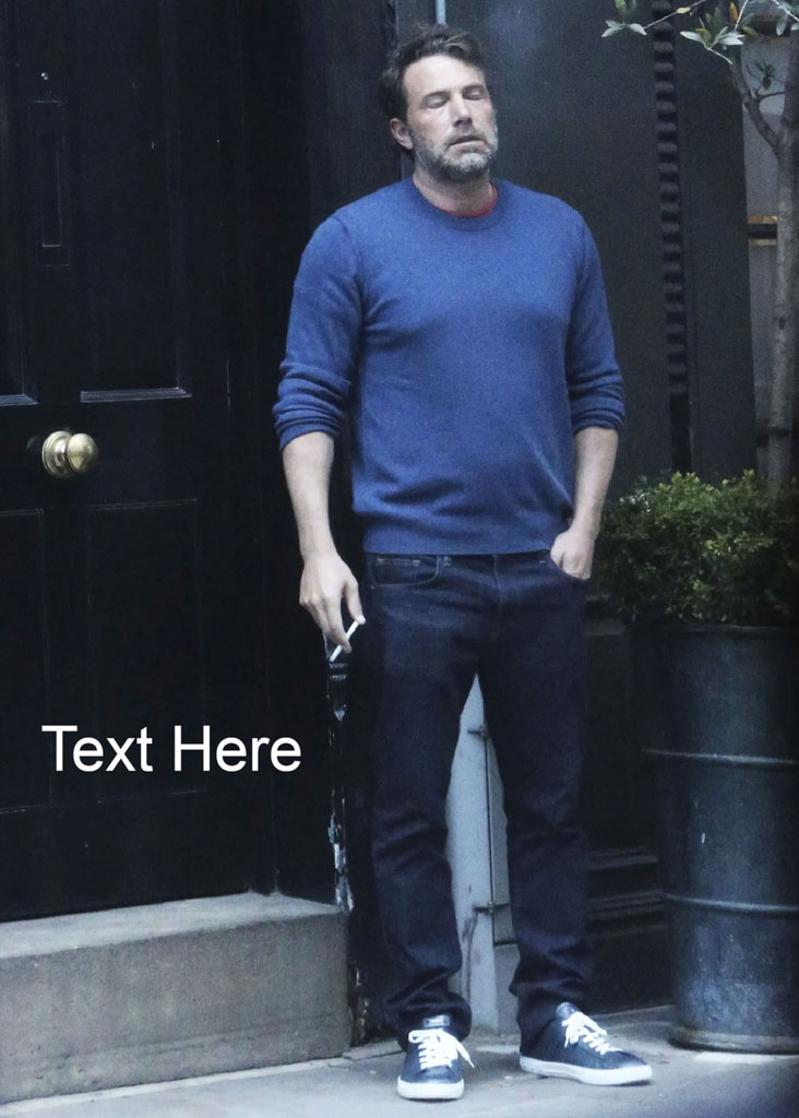 Man in blue sweater and jeans standing outside a black door