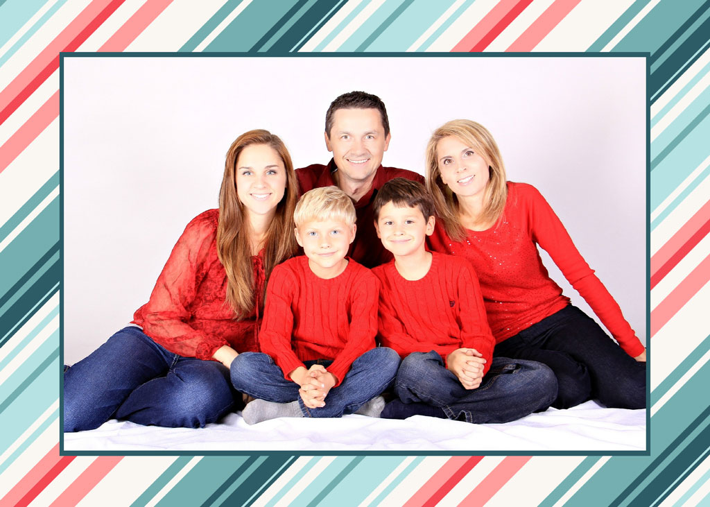 Family of five sitting together in matching red tops and jeans