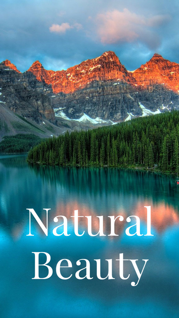 A lake surrounded by mountains and trees at sunrise or sunset.