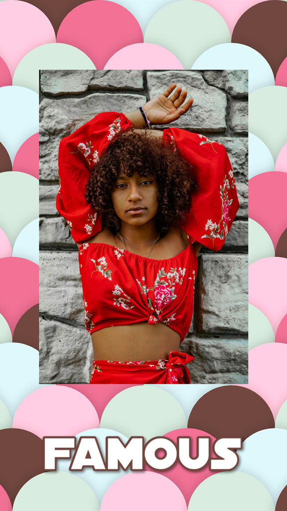 Young woman in red floral top and skirt posing against a stone wall