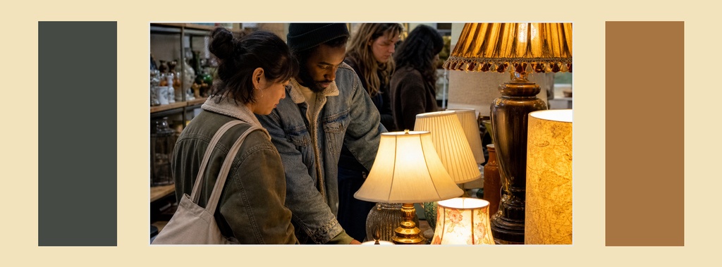 People browsing lamps and decor at a vintage market with color blocks on both sides.