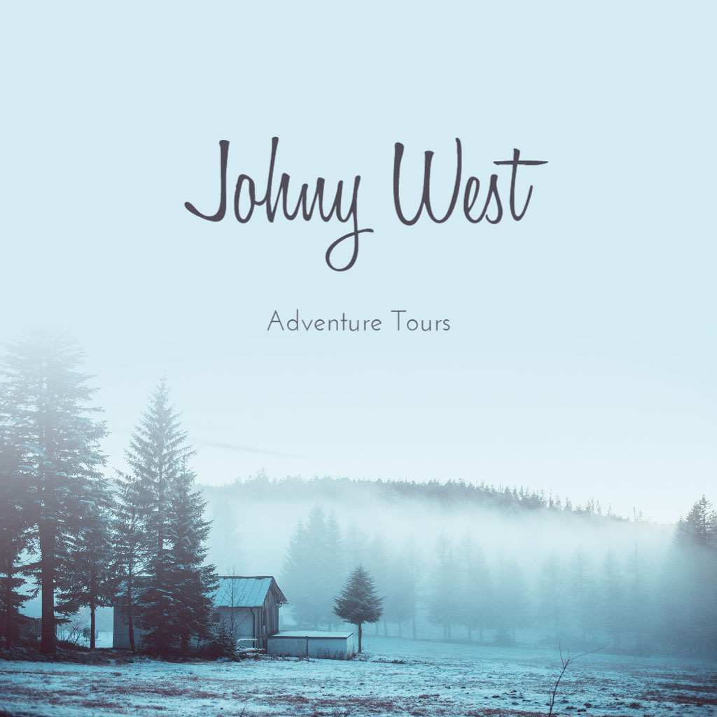 A serene winter landscape with a cabin and trees shrouded in mist, representing Johnny West Adventure Tours.