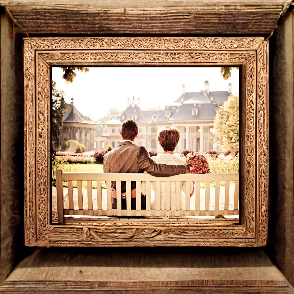 Couple sitting on a bench overlooking a large estate
