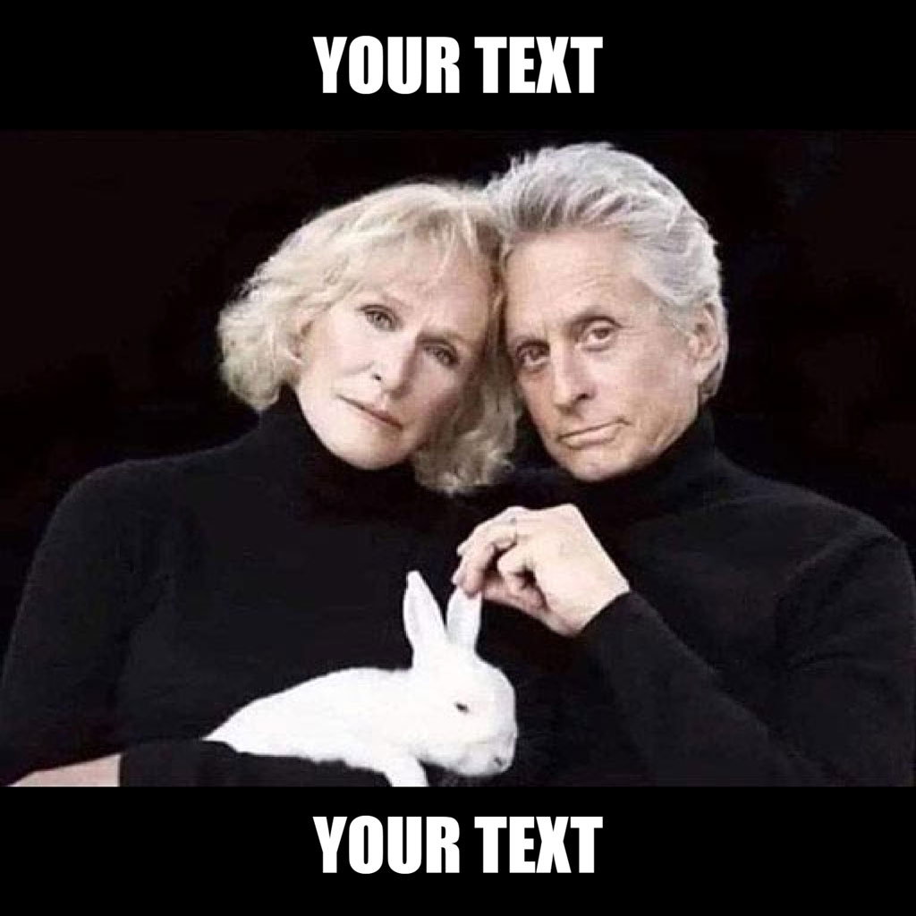 A man and woman in black turtlenecks holding a white rabbit