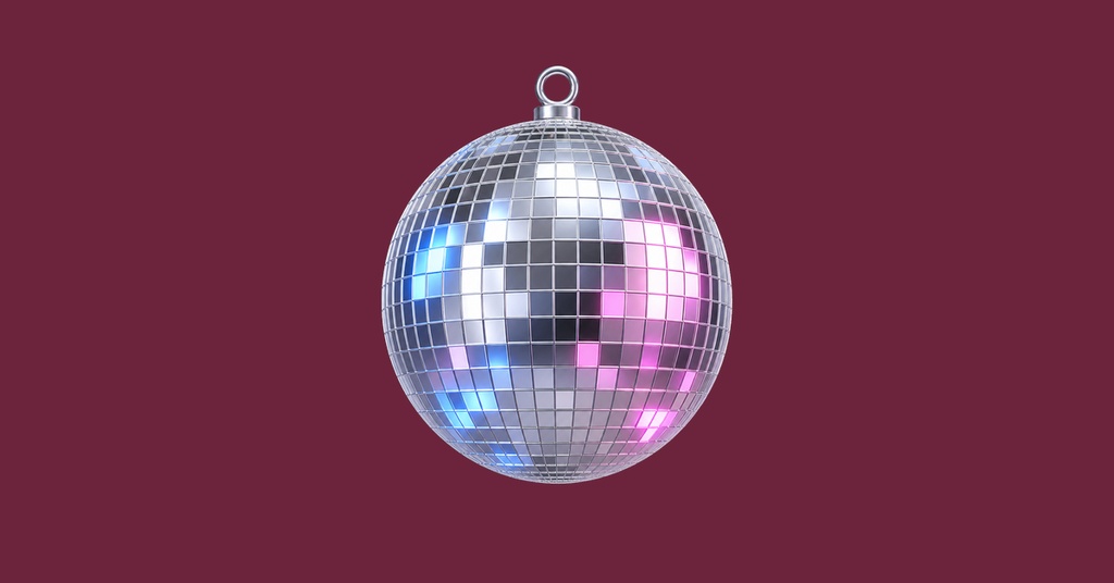 A silver disco ball hanging on a dark burgundy background.