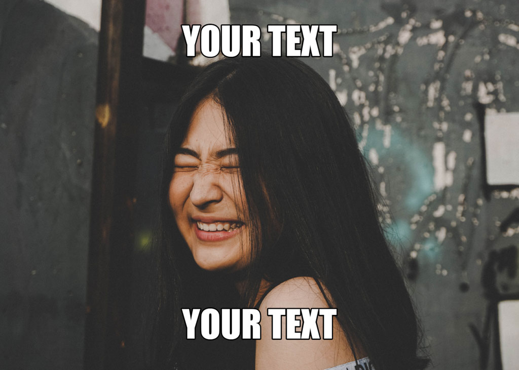 A woman with long black hair laughing in front of a blurred background.
