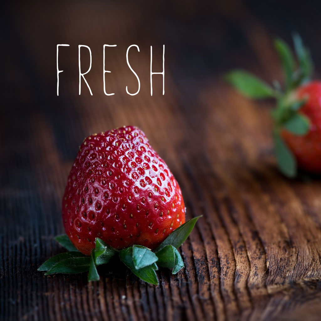 A ripe strawberry on a wooden table
