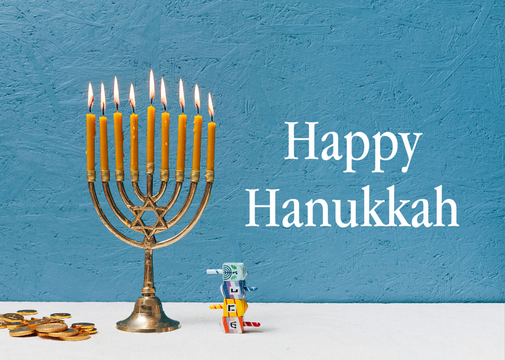 Hanukkah menorah with lit candles and a dreidel