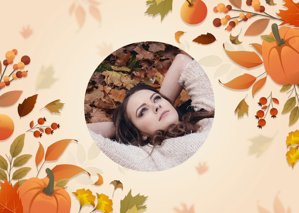 Woman lying on autumn leaves with pumpkins and foliage around her