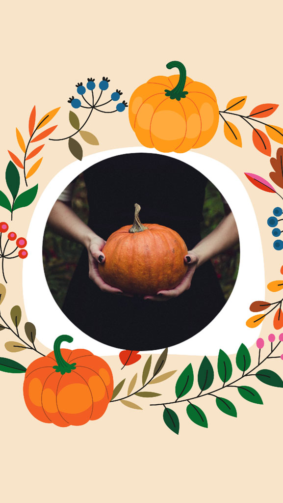 Hands holding a pumpkin surrounded by fall leaves and flowers