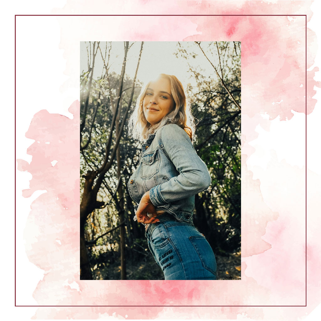 A young woman with blonde hair posing outdoors in denim clothing