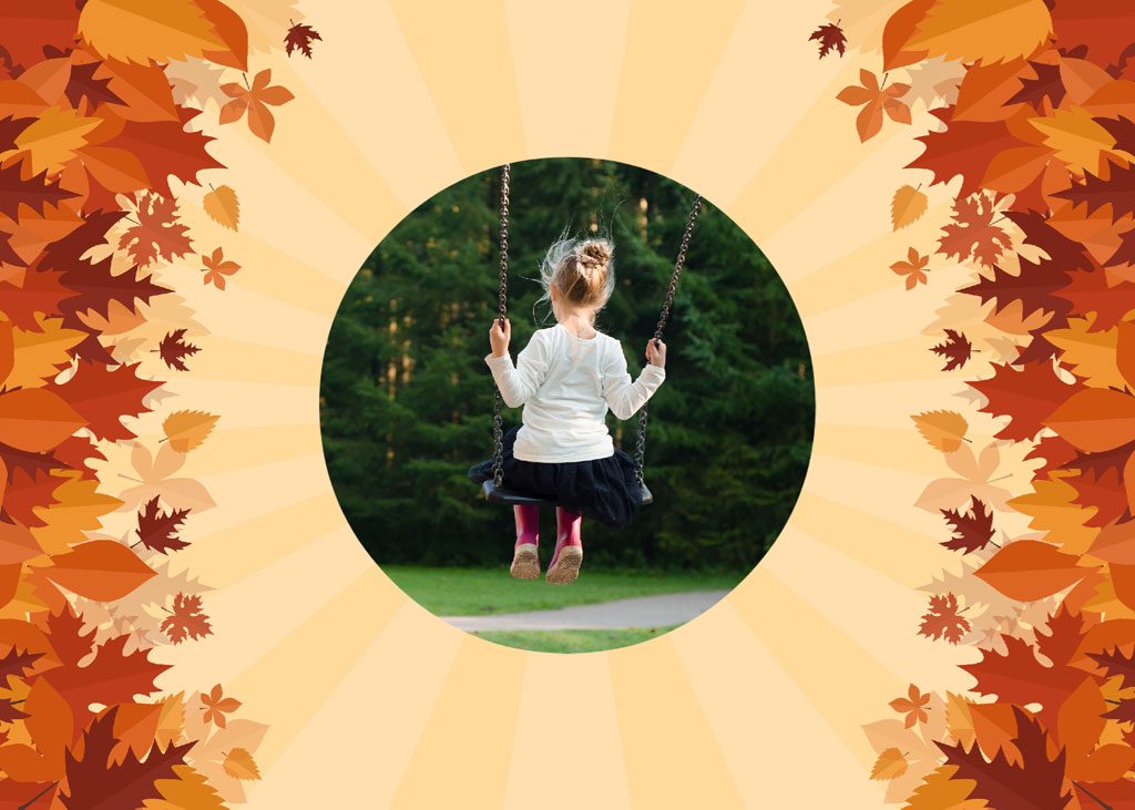 A girl on a swing in a park with fall leaves around